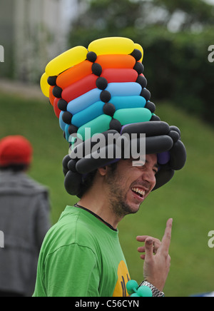 Homme portant un chapeau fait de ballons à l'Patchfest événement festival communautaire à Brighton, UK Banque D'Images