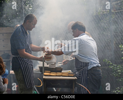 Beaucoup de fumée que les hommes cuire sur le BBQ à l'Patchfest événement festival communautaire à Brighton, UK Banque D'Images