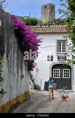 Obidos, Portugal : scène de rue avec une fille et un chien. Banque D'Images