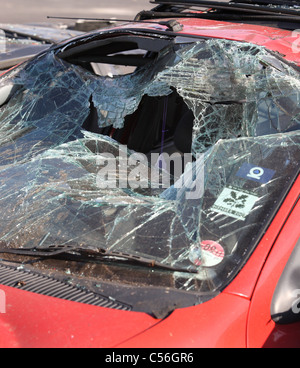 Pare-brise fracassé sur voiture rouge Banque D'Images