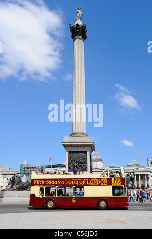 Scène de rue à Londres les touristes sur double decker bus visite guidée d'open top passant Nelsons Column à Trafalgar Square England UK blue sky summer day Banque D'Images