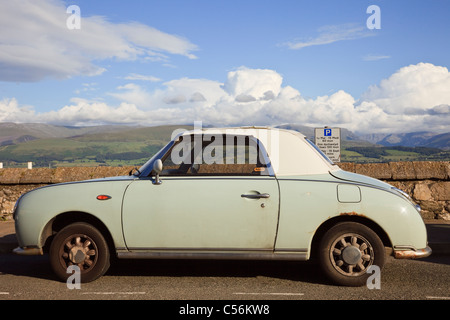 Style rétro vert Nissan Figaro automatic soft top sport coupé voiture garée sur le bord de mer. Anglesey, au nord du Pays de Galles, Royaume-Uni, Angleterre. Banque D'Images