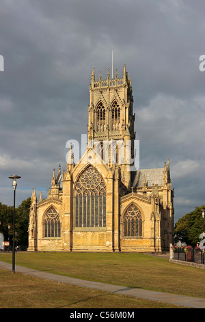 Doncaster Minster, église St Georges en plein soleil du matin contre un ciel en colère. Banque D'Images