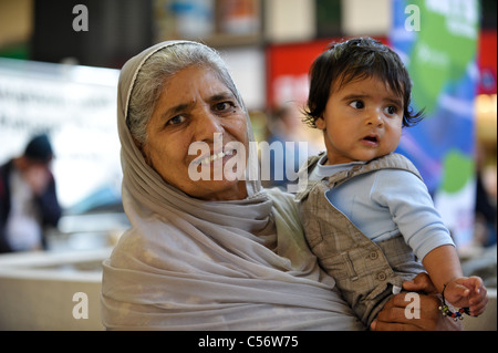 Grand-mère sikhe aux cheveux gris en robe traditionnelle indienne avec la tête couverte smiling holding son bébé petit-fils Banque D'Images