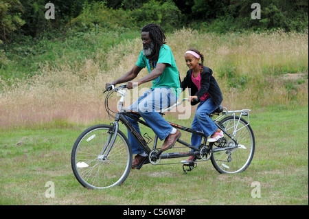 Man and girl riding un tandem dans la zone Uk Banque D'Images