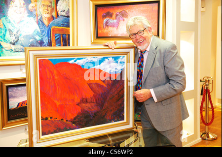 Artiste et présentatrice TV Rolf Harris détient un morceau de son origine art while smiling at camera Banque D'Images