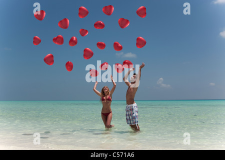 Couple Playing with balloons on beach Banque D'Images