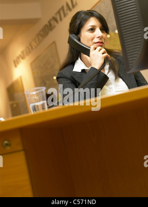Businesswoman talking on phone in office Banque D'Images