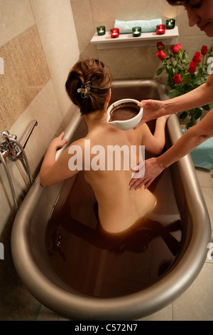 Femme dans une baignoire de chocolat Banque D'Images