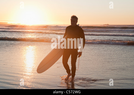 Surfer walking dans l'eau Banque D'Images