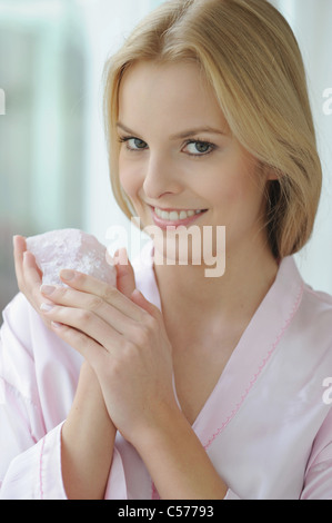 Smiling woman holding rose quartz Banque D'Images