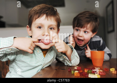 Les garçons faisant des grimaces à table Banque D'Images