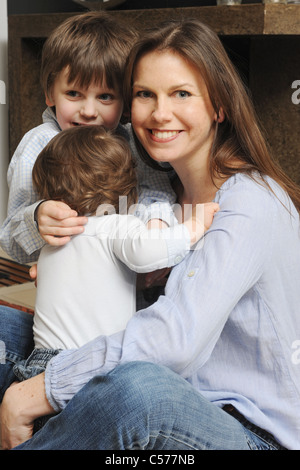 Mother hugging fils dans la salle de séjour Banque D'Images