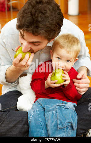 Le père et le fils ensemble manger des pommes Banque D'Images