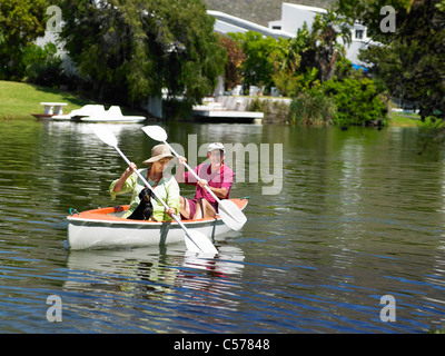 Vieux couple rowing canoe on lake Banque D'Images