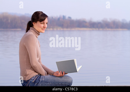 Femme assise avec réserve à l'extérieur Banque D'Images