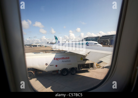 Bien qu'à la fenêtre à Exxon Mobil jet avions ravitailleurs de carburant faites le plein d'un avion de passagers 737 d'Air Canada à l'aéroport de Dublin Banque D'Images