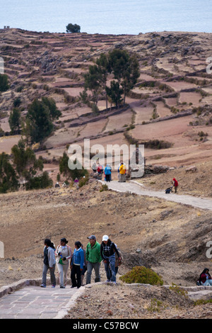 Les touristes et les visiteurs de marcher le long des chemins et des champs en terrasses de l'Île Amantani sur le lac Titicaca Banque D'Images