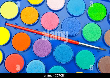 Les couleurs de l'eau dans une boîte de peinture avec pinceau Banque D'Images