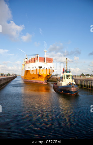 D'énormes porte-conteneurs avec tug boat dans lock Banque D'Images