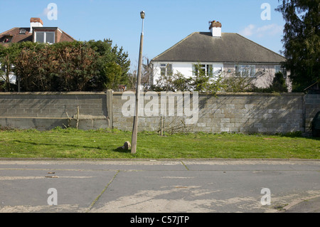 Habitat pavillonnaire, Sunbury on Thames, London. Lampost penchée et la paroi arrière. Banque D'Images