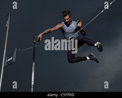 Man jumping Saut à la perche en plein vol. Banque D'Images