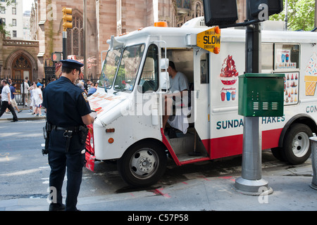 Un agent de police de billets d'un camion de crème glacée à Broadway dans le Lower Manhattan à New York Banque D'Images