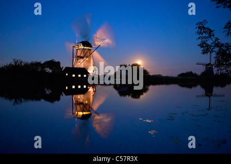 Les Pays-Bas, Kinderdijk, éclairé moulin, UNESCO World Heritage Site. Lever de lune. Banque D'Images