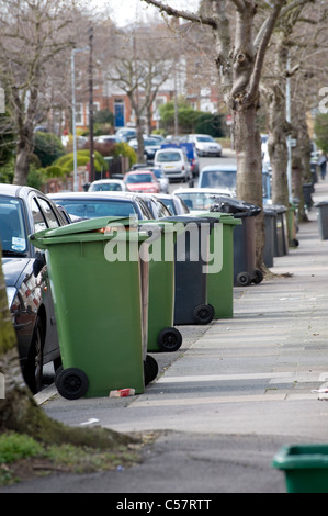 Wheelie bins contenant les ordures ménagères en attente de collecte à l'extérieur d'une maison en Angleterre. Banque D'Images