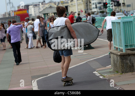 Un jeune surfer sur la photo avec son bord tandis que la planche à roulettes à Brighton, East Sussex, UK. Banque D'Images