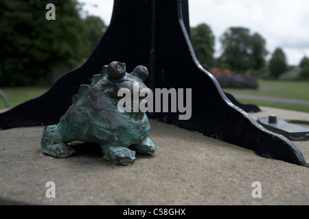 Détail crapaud sculpture dans le parc Victoria Newbury Berkshire England UK avec des arbres et des fleurs dans l'arrière-plan Banque D'Images