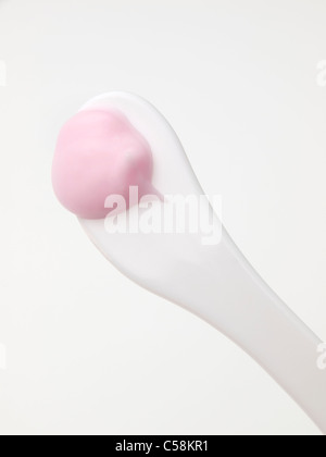 Spatule en plastique blanc avec de blob rose crème de beauté Banque D'Images