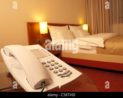 Chambre avec téléphone à l'avant et lit dans l'arrière-plan, l'accent sur le téléphone,pour le service en chambre,thèmes communication Banque D'Images