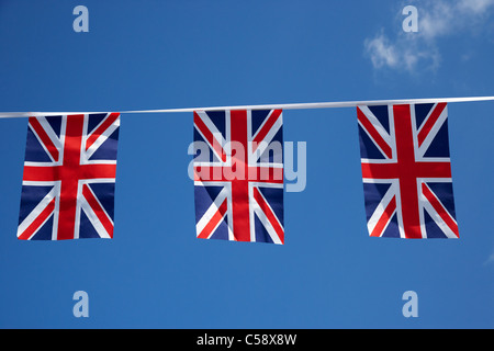 British union flag bunting bannière voler contre un ciel bleu au Royaume-Uni Banque D'Images