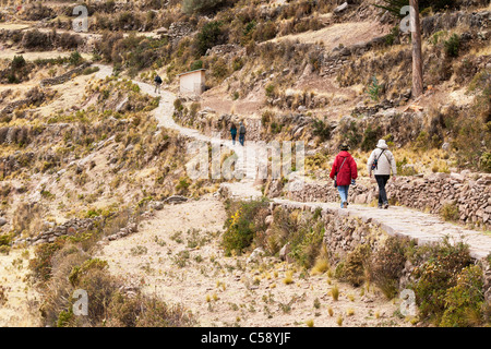 Un couple une randonnée autour de les chemins et sentiers de l'île de Taquile sur le lac Titicaca au Pérou Banque D'Images