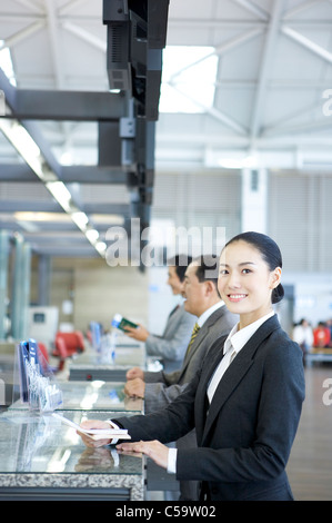 Portrait of businesswoman giving passeport et le billet au comptoir Banque D'Images