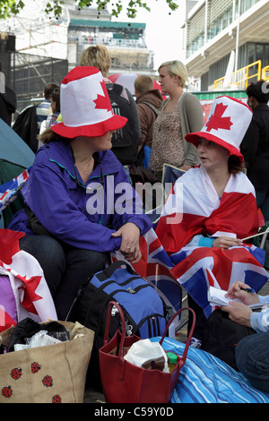 Le mariage royal 2011, assis parmi une foule de personnes ont campé deux Canadiens femmes en face de l'abbaye de Westminster ont un chat. Banque D'Images