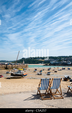 St Ives Harbour et plage, à marée basse dans l'été avec deux transats à l'avant-plan. Cornwall, UK. Banque D'Images