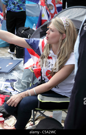 Le mariage royal 2011, jeune femme blanche campé et assis en face de l'abbaye de Westminster et dûment l'attente du grand jour. Banque D'Images