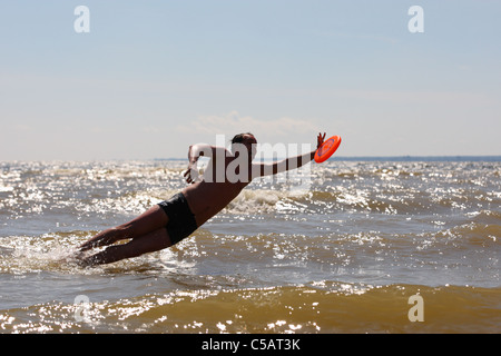 Jeune homme attraper un disque volant Banque D'Images