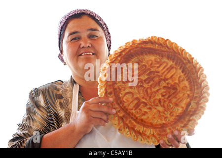 Friendly Uzbeki vendeur avec pain pain style Uzbeki comme cuit dans un four tandoor. Samarkand, Ouzbékistan Banque D'Images