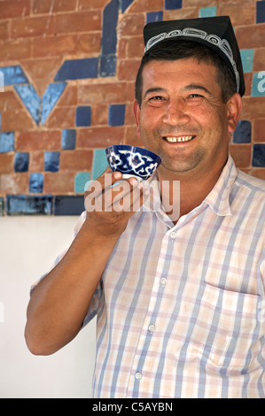 Friendly Uzbeki homme dans un syle Uzbeki hat et boire le thé, une boisson de tous les jours à Samarkand, Ouzbékistan Banque D'Images