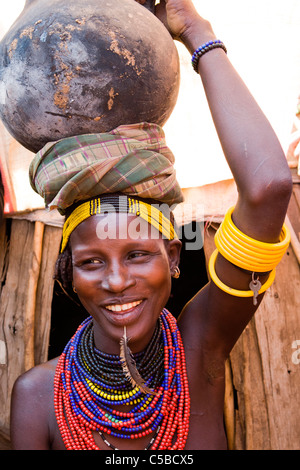 Portrait d'un Galeb / Dassanech tribeswoman portant un pot à l'eau de l'argile sur la tête dans la basse vallée de l'Omo, dans le sud de l'Éthiopie. Banque D'Images