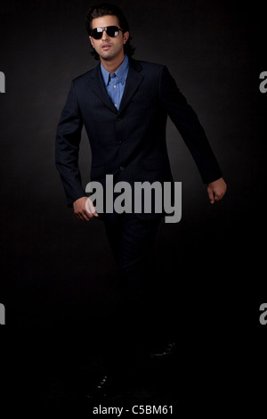 Young business man walking en fond noir isolé Banque D'Images