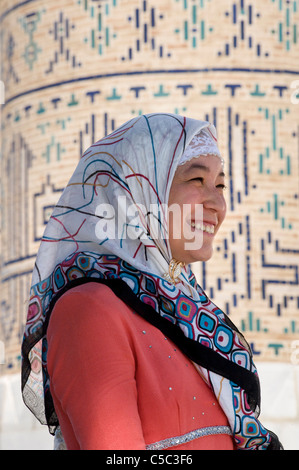 Uzbeki femme en tenue à l'extérieur distinctif Uzbeki mosquée Bibi Khanym, Samarkand, Ouzbékistan Banque D'Images