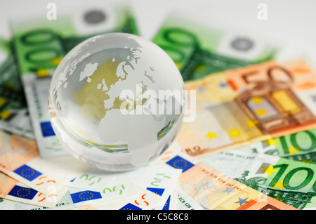 Globe en verre et la variété des billets tourné sur un fond blanc Banque D'Images