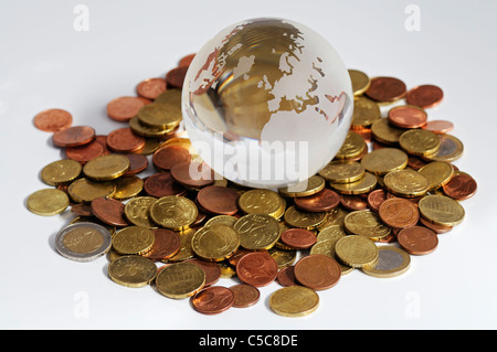 Close-up du globe de verre et pièces tourné sur un fond blanc Banque D'Images