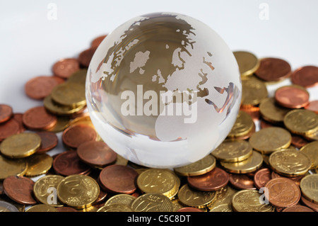 Close-up du globe de verre et pièces tourné sur un fond blanc Banque D'Images