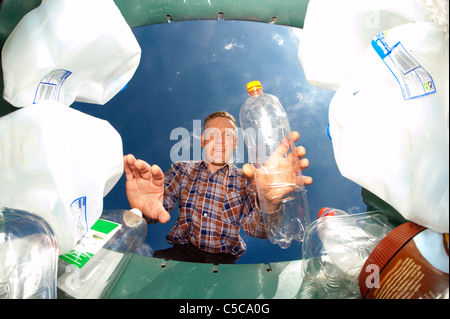 Man throwing bouteille plastique bac de recyclage dans le vert pour le recyclage Banque D'Images