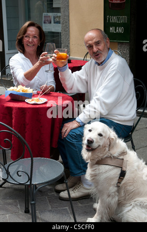 Middle-aged couple italien et de leur chien profiter de la Dolce Vita dans un café à Como Banque D'Images